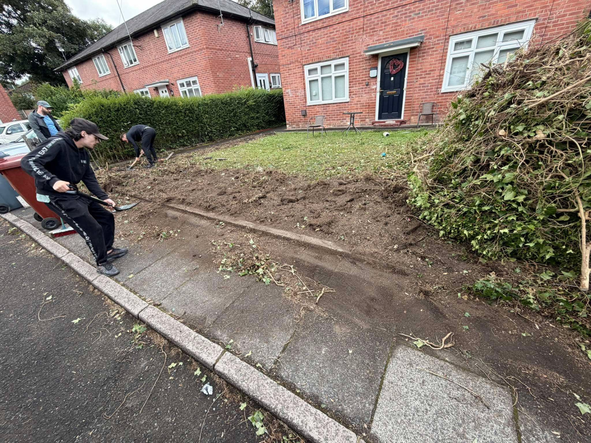 Site clearance — Team clearing overgrowth and debris from a Manchester property
